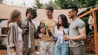 Bir şeyleri kutlayan, bira içen, dışarıda karavanın yanında parti yapan bir grup mutlu çok ırklı genç arkadaş. Milenyum çeşitliliği yaz tatilinin tadını çıkarıyor.