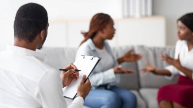 Kızgın LGBT lezbiyen çifti evlilik danışmanıyla seans sırasında tartışıyor, birbirleriyle tartışıyorlar. Profesyonel yardıma ihtiyaç duyan eşcinsel eşler terapist ofisinde