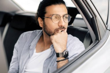 Arabasında oturan düşünceli bir Arap adam, taksiyle bir yere giderken bir şeyler hayal ediyor, dalgın bir orta doğulu yolcu camdan içeri bakıyor, eline yaslanıyor, uzayı kopyalıyor.