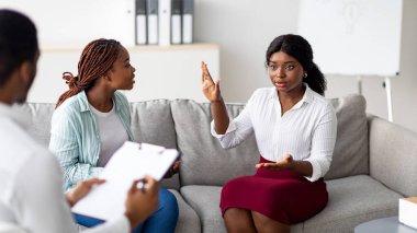 Ofiste psikologla görüşen Afro-Amerikalı lezbiyen çift. Genç LGBT homoseksüel ailesi ilişkilerinde profesyonel yardım alıyor