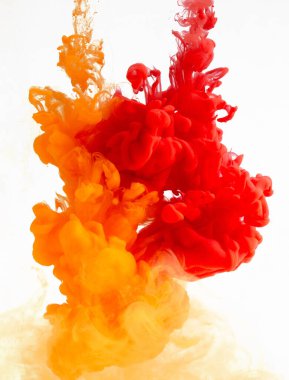 Sudaki sarı ve kırmızı mürekkep soyut şekil yaratıyor, beyaz arkaplanda izole edilmiş.