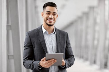 Havalimanı Terminalinde Ellerinde Sayısal Tabletle Gülümseyen Genç Orta Doğulu Adam, Uçuşunu Beklerken Sekme Bilgisayar kullanan başarılı Arap İşadamı, Uzay Kopyala