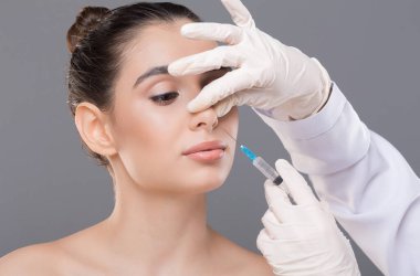 Estetik burun ameliyatı. Doktor kadın burnuna enjeksiyon yapıyor. Alternatif burun ameliyatı.