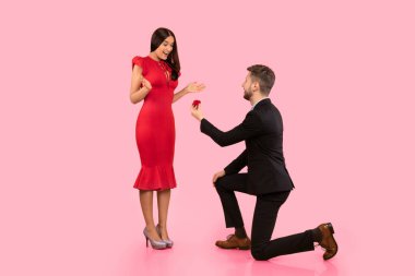 Evlen benimle. Erkek arkadaşı dizlerinin üstünde durup, sarı arka plandaki kız arkadaşına nişan yüzüğü vermeyi teklif ediyor. Stüdyo Çekimi