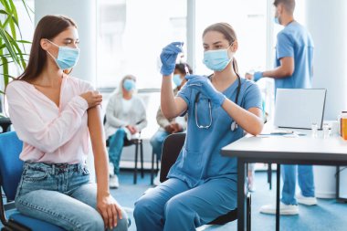 Genç bayan için şırınga dolduran bir şişe grip aşısı tutan bir kadın. İlaç alıyor. Sağlık merkezinde kitle aşılama programı. Corona virüsü önleme, koruma