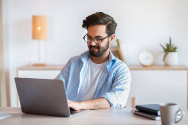 Gülümseyen Arap Girişimci, İçişleri Bakanlığı 'nda dizüstü bilgisayarla çalışıyor, online proje için bilgisayarını kullanıyor, Doğu Erkek Serbest Çalışan, Uzak İş Fırsatlarından keyif alıyor, Boşluğu Kopyalıyor