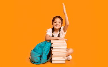 Zeki ilkokul çocuğu, cevapların sarı arka planda saklandığını bilerek el kaldırıyor. Stüdyo Çekimi, Boş Alan