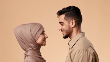 Orta Doğulu genç bir çift, yumuşak bir geçmişi olan bir stüdyoda karşı karşıya duruyor. Koca tesettürlü karısına gülümsüyor. İfadeleri aşkı ve arkadaşlığı ifade eder..