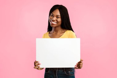 Mavi Stüdyo Arkaplanının Üzerinde Duran Mesajınızın Reklamını Veren Boş Kağıt Gösteren Afro-Amerikan Kadın. Kameraya gülümseyen boş posterli siyah kadın. Reklam afişi. Model