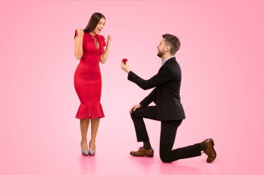 Evet dedi. Erkek Kız Arkadaşına Yüzüğünü Kutuda Teklif Ediyor Stüdyoda Diz çökmüş Sarı Arkaplanda