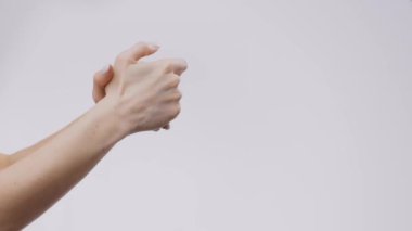 Genç bir kadın, ellerine minimalist bir ortamda cilt bakım ürünleri uygularken görülüyor. Bu rutin, kendini şımartmanın önemini vurgulayarak, kişisel bakım ve susuzluğu vurgular..