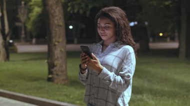 Genç bir Afrikalı Amerikalı kadın geceleri sessiz bir sokakta tek başına yürüyor. Etrafı ağaçlarla ve sönük sokak lambalarıyla çevrili telefonunu kontrol ediyor, serin bir akşamın tadını çıkarıyor..