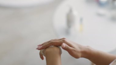 Genç bir Afro-Amerikalı kadın evde kendine bakmaktan zevk alıyor, cildine yatıştırıcı krem sürüyor. Sıcak atmosfer onun güzellik rutinini arttırıyor..