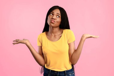 Seçim ve Karşılaştırma Konsepti. Mavi arkaplandan hangisini seçeceğini düşünen iki görünmez nesneyi tutan düşünceli Afrikalı Amerikalı kadın. Stüdyo Çekimi