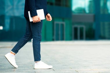 Sokakta yürüyen modern dijital tabletle tanınmayan genç adam, fotokopi alanına, panorama 'ya, ofis binalarına doğru giden bir IT yöneticisi. İş dünyasındaki teknolojiler