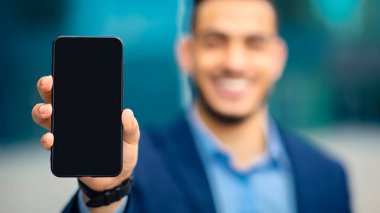 Modern teknolojiler ve iş konsepti. Tanımlanamayan işadamı akıllı telefonu boş ekran ile gösteriyor, iş, finans ve seçici odaklanma için yepyeni cep telefonu uygulamaları öneriyor