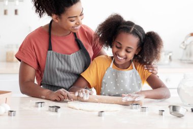 Afro-Amerikan annesini sevmek, ergen kızına kurabiye pişirmede yardım etmek, önlük takan güzel siyah anne ve çocuk, evde birlikte hamur işi yapmak, mutfak içi, kopyalama alanı.
