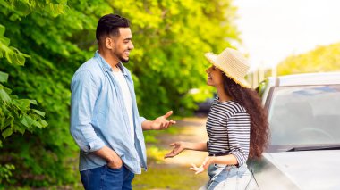 Olumlu Arap erkek ve kadın güzel bir arabanın yanında durup sohbet ediyorlar, orta doğulu çiftler birlikte araba gezisine çıkıyorlar ya da yaz tatiline çıkıyorlar, kırsal kesimde mola veriyorlar.