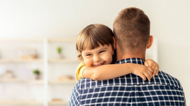 Çocuk mutluluğu. Mutlu küçük çocuğun yakın portresi. Sevgili babasını kucaklıyor. Sevgili babasıyla olan bağının tadını çıkarıyor.
