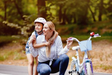 Parkta bisiklete binmeyi öğrenen, koruyucu kask takan bir kız çocuğu. Aile Haftasonu Adveture Konsepti