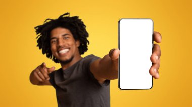 Neşeli siyah adam elinde boş beyaz ekranla akıllı telefon gösterisi yapıyor, neşeli genç Afrikalı Amerikalı adam reklam ya da tasarımın için bedava fotokopi alanı gösteriyor, bej arka planda duruyor,