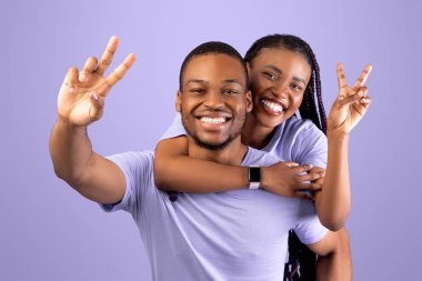 Romantik Siyah Çift Birlikte Eğleniyor, İki Parmaklı V Barış Sembolü Sembolü Gösteriyor, Neşeli Afrikalı Amerikalı Adam Mutlu Kız Arkadaşı, Neşeli Kadın Erkeklerin Sırtına Biniyor