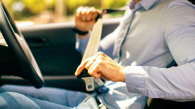 Resmi kıyafetli Arap bir adam. Otomobil emniyet kemeri takıyor. Orta Doğulu bir girişimciye yakın çekim yapıyor. Güzel bir araba kullanıyor. Güvenli sürüş kavramı