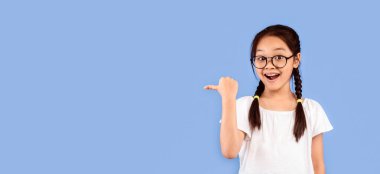 Şuraya bak. Heyecanlı Koreli kız, Purple Stüdyo Arkaplanındaki Mesaj Pozisyonu için Başparmağıyla Boş Yeri Gösteriyor. Panorama