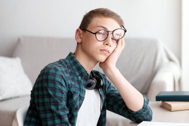 Evde ödev yaparken uyuyan yorgun okul çocuğu, boşluğu kopyala