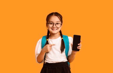 Asyalı Liseli Kız Akıllı Telefon Boş Ekran Uygulaması Gösteriyor Sarı Stüdyo Arkaplan Üzerinde Kamera Pozisyonuna Gülümsüyor