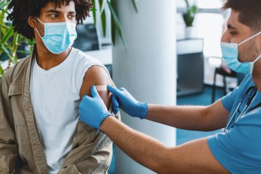 Gribe karşı aşı olan Afrikalı Amerikalı adam Coronavirüs antiviral aşı enjekte ettikten sonra Corona Virüsü 'ne karşı aşı olan doktor,
