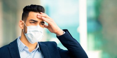 Stresli, orta doğulu, maske takan iş adamının ofis binasının yanında dikilip, kafaya dokunması, iş yerinde sorun yaşaması, covid-19 salgını, fotokopi alanına bakması...