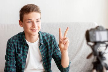 Memleketten yayın yapan ünlü genç blog yazarı barış jesti gösteriyor