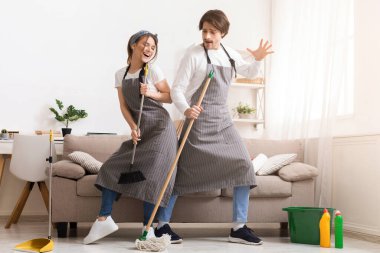 Zevkle temizliyorum. Neşeli çift evlerini toplarken, paspas ve süpürge ile dans ederken, boş alanda eğleniyor.