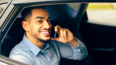 Neşeli bir ortadoğulu genç adam yönetici ofise taksiyle giderken iş ortağıyla konuşuyor, arabanın arka koltuğunda oturuyor, yakın plan portresi, fotokopi odası. İş adamı yaşam tarzı konsepti