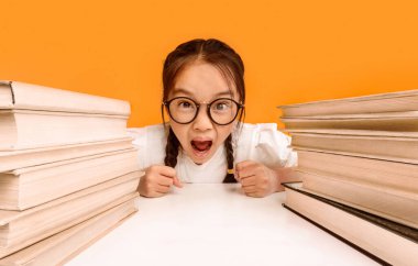 Kızgın Çinli Liseli Kız Sarı Arkaplan Üzerine Oturan Kitaplar 'da Bağırıyor. Okuldaki kötü davranışlar. Stüdyo Çekimi