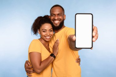 Yeni harika mobil uygulama. Afro-Amerikan çift akıllı telefonları sunuyor, uygulamayı veya web sitesini tanıtıyorlar, ürününüzü veya servisinizi tanıtıyorlar, mavi stüdyo geçmişi var. Seçici odak