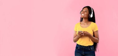 Müzik Uygulaması. Blue Studio 'nun arka planında duran kablosuz kulaklıkla müzik dinleyen mutlu Afrikalı Amerikalı kadın. Metin için Boşluk