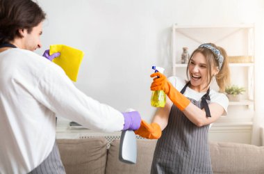 Komik Ev Temizliği. Pozitif bir çift, birlikte daireleri toplamaktan zevk alıyor, birbirlerine ateş ediyorlar ve gülüyorlar, birbirlerine yaklaşıyorlar.