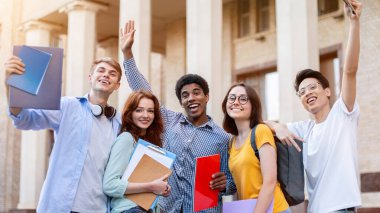 Üniversite binasının dışında poz veren birinci sınıf öğrencileri, üniversiteye girdikleri için heyecanlılar. Eğitim Konsepti