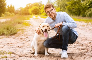 Hayvan Sevgisi Konsepti. Gözlüklü neşeli adamın portresi oturup sevgili köpeğini kucaklıyor, kopyalama alanı.