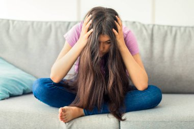 Kanepede el ele oturan Hintli genç kız, olumsuz düşüncelere dalmış, evde depresyona girmiş, uzun bir süre boyunca. Sinir krizi geçiren mutsuz ergen, çaresiz hissediyor.