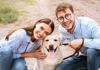 Aile kavramı. Romantik mutlu çift kırsaldaki evcil hayvanlarıyla eğleniyor.