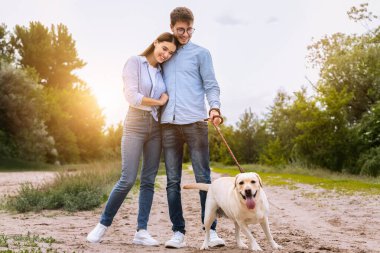 Aileyle vakit geçirmek. Sakin, güzel eşler kırsalda yavru köpeklerine sarılıp geziyorlar.