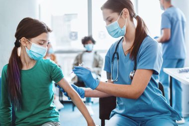 Bağışıklık, Önleme Prosedürü Konsepti. Cerrahi maske takan genç hastaya yakın çekim. Tıp Merkezi 'nde doktor randevusu sırasında koluna enjekte edilen kas içi enjeksiyon.