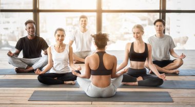 Eğitmenle Yoga Dersi. Afrikalı Amerikalı Kadın Yogi Koçu Asanas 'ı Gruba Açıklıyor, Lotus pozisyonunda Birlikte Oturuyorlar, Modern Stüdyo, Serbest Alan