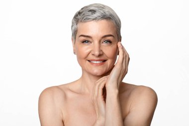 Yaşlanmış Güzel. Çekici, çıplak, olgun bir kadının portresi kameraya gülümseyen, arka planda poz veren, serbest alan.