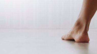 Süslü bir milenyum kadını, sakin bir yaşam tarzını sergileyerek, parlak bir yatak odasında yalınayak dolaşır. Rahat bir bornoz giyiyor, evinin huzurunu kucaklıyor..