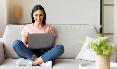 Başarılı bir Freelancer. Dizüstü bilgisayarda çalışan bir kadın evdeki koltukta oturuyor. Boş Alan, Seçici Odaklanma