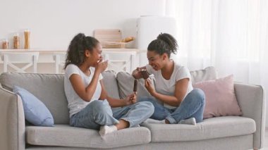 İki Afrikalı Amerikalı kız kardeş evlerinde bir kanepede oturmuş birbirleriyle şakalaşıyorlar. Sıcak atmosferde kahkaha ve şefkat paylaştıkça bağları daha da belirginleşiyor..